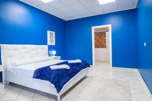 a blue bedroom with a bed and a blue wall at Royal Playa Suite and Apartament -private parking- self chek out in Catania