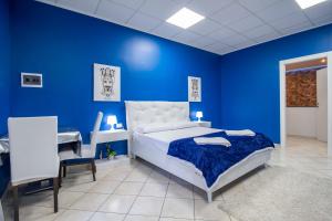a blue bedroom with a bed and a desk at Royal Playa Suite and Apartament -private parking- self chek out in Catania