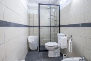 a bathroom with a toilet and a glass shower at Royal Playa Suite and Apartament -private parking- self chek out in Catania