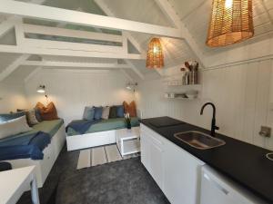 cocina con 2 camas y lavabo en una habitación en Tranum Klit Camping og Hytteudlejning, en Brovst