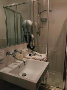 y baño con lavabo y ducha. en Hotel Resort La Rosa Dei Venti, en Portopalo di Capo Passero