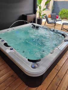 a jacuzzi tub sitting on a wooden floor at Gîte des granges in Alençon