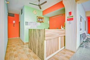 eine Küche mit orangefarbenen und grünen Wänden und einer Theke in der Unterkunft Hotel O Sri Sai Guru Comforts in Bangalore