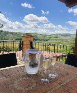 dos vasos de vino blanco sentados en una mesa en Colle Indaco Wine Resort & Spa, en Ortezzano