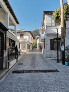 an empty cobblestone street in a town with buildings at ΠΑΝΑΓΙΑ ΠΑΡΑΔΟΣΙΑΚΟ ΣΠΙΤΙ in Panayia