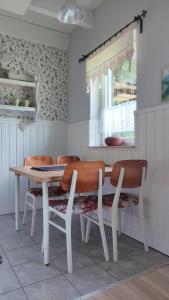 a kitchen with a table and chairs and a window at Iskierkówka in Brenna