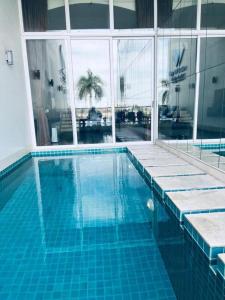 a swimming pool in a building with a large window at Blue Crystal boutique Hotel in Phnom Penh