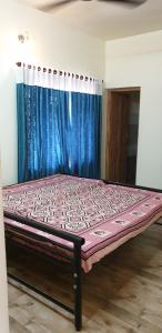 a bed in a room with a blue curtain at Signature Grande Villa, Kalathipady, Kottayam in Kottayam