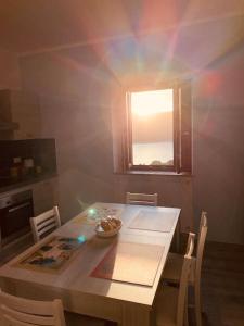 a kitchen with a table with chairs and a window at La Dimora del Turano in Castel di Tora