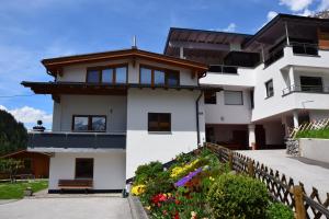 a white house with flowers in front of it at Apart Belvita in Sankt Leonhard im Pitztal +12 photos