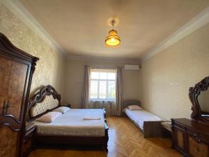 1 dormitorio con 2 camas y ventana en Valiko house in Telavi en Tʼelavi