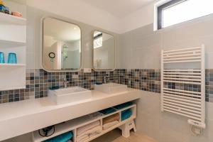 un bagno con due lavandini e due specchi di Villa Valle di Corte - Avec piscine et vue mer a Pianottoli-Caldarello Altre 22 foto
