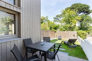 a patio with a table and chairs on the side of a house at La Fleur du Moulin - Charmante maison avec jardin proche plage in Saint-Briac-sur-Mer