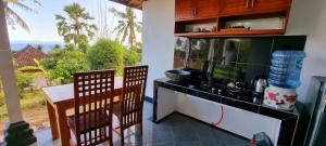 cocina con encimera, mesa y sillas en Frangipani Inn & Restaurant, en Seraya