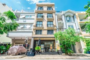 a tall white building with trees in front of it at Spring Hill Apartment -The High Class in Ho Chi Minh City