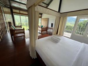 1 dormitorio con 1 cama en una habitación con ventanas en The Farmhouse Mahaulpatha en Bandarawela