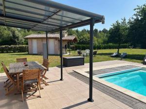 a patio with a table and chairs next to a swimming pool at Mélité in Grayan-et-lʼHôpital