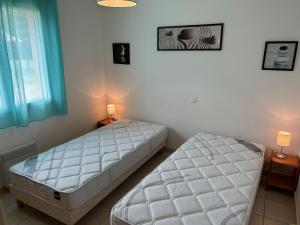 two beds in a bedroom with two lamps and a window at Mélité in Grayan-et-lʼHôpital +39 photos