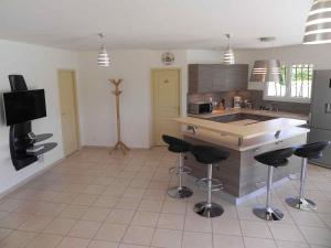 a kitchen with a counter and bar stools in it at Mélité in Grayan-et-lʼHôpital