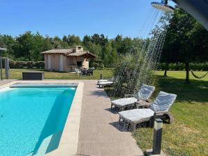 a swimming pool with two lounge chairs next to it at Mélité in Grayan-et-lʼHôpital