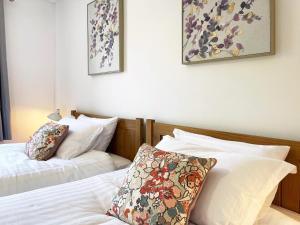 two beds in a bedroom with two pillows on them at Grace's Place in Ely in Ely