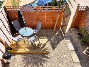 een patio met een tafel en stoelen en een hek bij Grace's Place in Ely in Ely