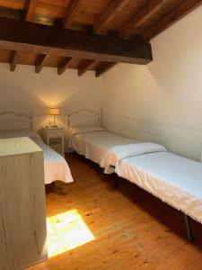 にあるCASA EL PELAMBREのウッドフロアと木製の天井が特徴の客室で、ベッド2台が備わります。