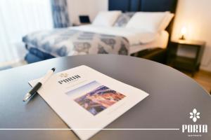 a table with a pen on top of a table with a bed at Porta Apartman Sarajevo in Sarajevo