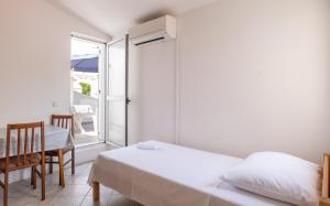 1 dormitorio con cama, mesa y ventana en Apartments Center Pag 50 m to the sea, en Pag