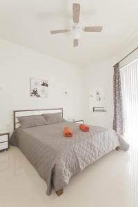 Un dormitorio con una cama con un sombrero naranja. en Waterside Apartments, en Marsalforn
