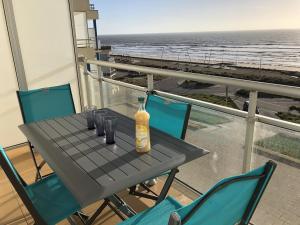 - une bouteille de vin sur une table sur un balcon donnant sur la plage dans l'établissement Appartement Saint-Hilaire-de-Riez, 2 pièces, 4 personnes - FR-1-224C-27, à Saint-Hilaire-de-Riez