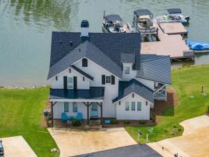 an aerial view of a large white house on the water at Lake Happy in Dadeville