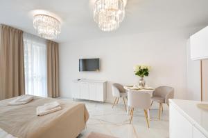 um quarto branco com uma cama, uma mesa e cadeiras em PLATINUM Prywatny Apartament w Hotelu Diva em Kolobrzeg