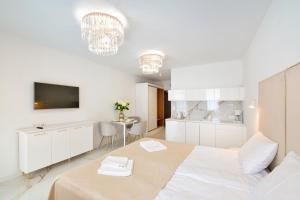 um quarto branco com uma cama e uma cozinha em PLATINUM Prywatny Apartament w Hotelu Diva em Kolobrzeg