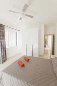 a bedroom with a bed with two orange pillows on it at Waterside Apartments in Marsalforn