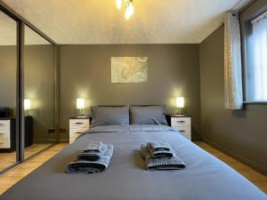 a bedroom with a large bed with two towels on it at No24 - 2-bed Boutique Apartment - Hosted by Hutch Lifestyle in Leamington Spa