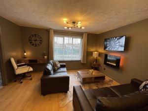 een woonkamer met een bank en een stoel bij No24 - 2-bed Boutique Apartment - Hosted by Hutch Lifestyle in Leamington Spa