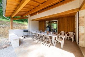 un comedor al aire libre con mesa y sillas en La maison dans la nature - Cadre exceptionnel au bord de cours deau, en Sainte-Livrade-sur-Lot