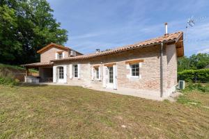 a small brick house with a yard at La maison dans la nature - Cadre exceptionnel au bord de cours deau in Sainte-Livrade-sur-Lot