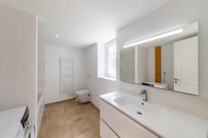 a white bathroom with a sink and a toilet at La maison dans la nature - Cadre exceptionnel au bord de cours deau in Sainte-Livrade-sur-Lot +12 photos