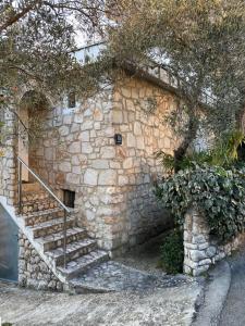 a stone building with a staircase next to a wall at Apartment Tihana in Cres