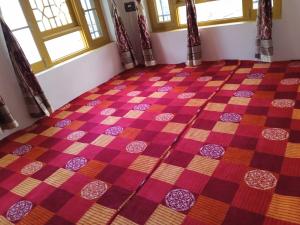 una camera con pavimento a scacchi e finestre di OYO Home Shugufta Villa Homestay a Gāndarbal