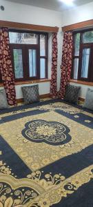 Habitación con una alfombra grande en el suelo y ventanas en POP Maryam Homestay en Gāndarbal