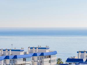 un edificio con balcones azules junto al océano en FUNNY FRIENDLY FISH HOLIDAY APARTMENTS, en Benalmádena