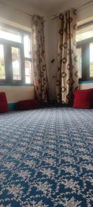 una camera con moquette e finestre blu e bianche di POP Maryam Homestay a Gāndarbal