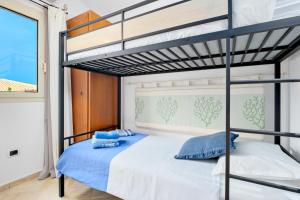 a bedroom with a bunk bed with blue pillows at Villetta Azzurro - SHERDENIA Luxury Apartments in Marinella +20 photos