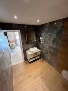 a bathroom with a sink and a glass shower at H&H Rooms Rovinj - Adults Only in Rovinj