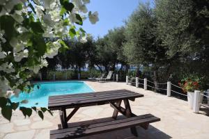 Un banco de madera sentado junto a una piscina. en Banana Sunset Villas, en Pafos