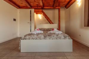 - 2 chiens dormant sur un lit blanc dans une chambre dans l'établissement Residenza Anna Calabria, à Briatico