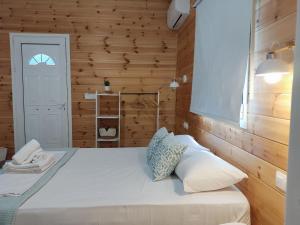 1 dormitorio con 1 cama con pared de madera en Elafonisos Loft A3, en Elafonisos